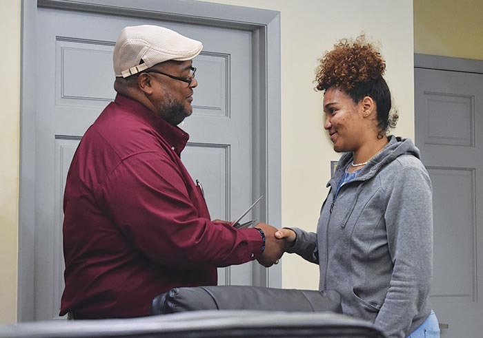 Executive Director Anthony Woods shaking a graduates hand