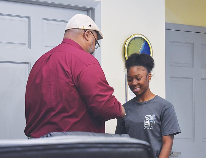 Executive Director Anthony Woods speaking to a recent female graduate